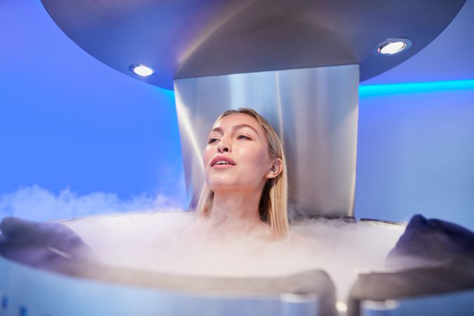 Blonde woman relaxing in cryotherapy chamber