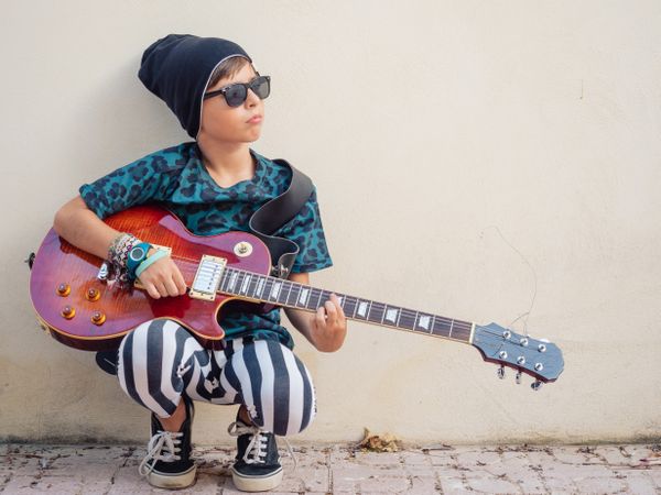 Energetic kid holding guitar