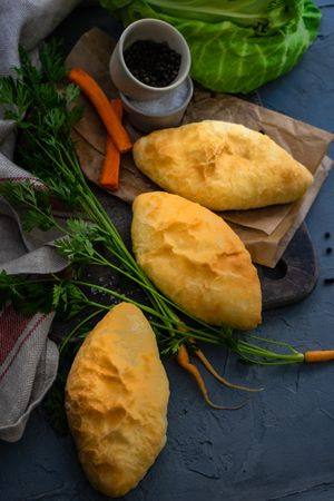 Traditional savory pies with cabbage and carrot on counter