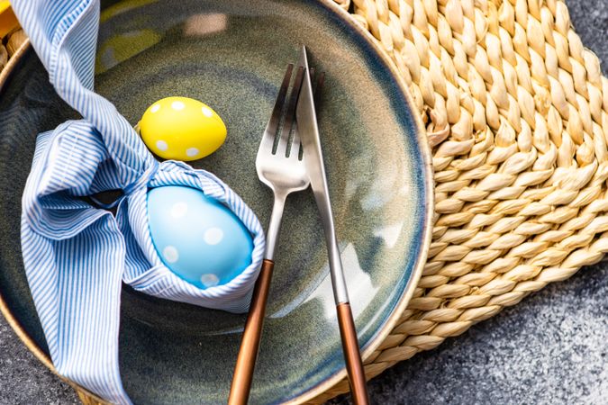 Easter holiday table setting with yellow & blue egg decoration on plate