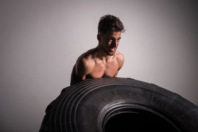Man flipping big tires in gym