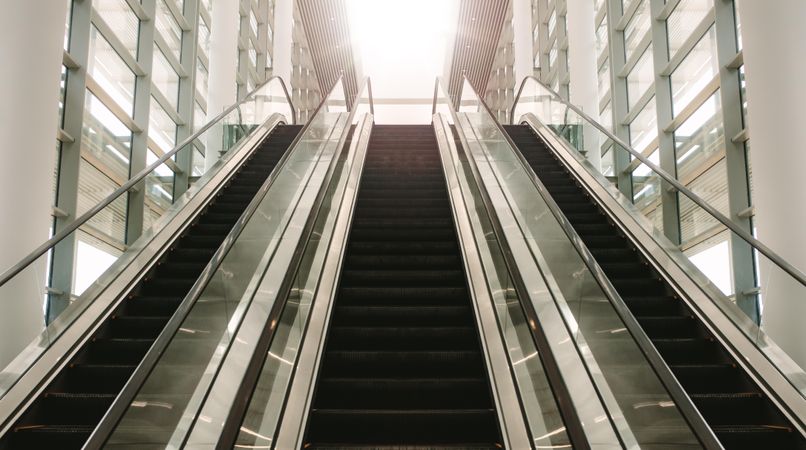 Empty bank of escalators leading out of a building