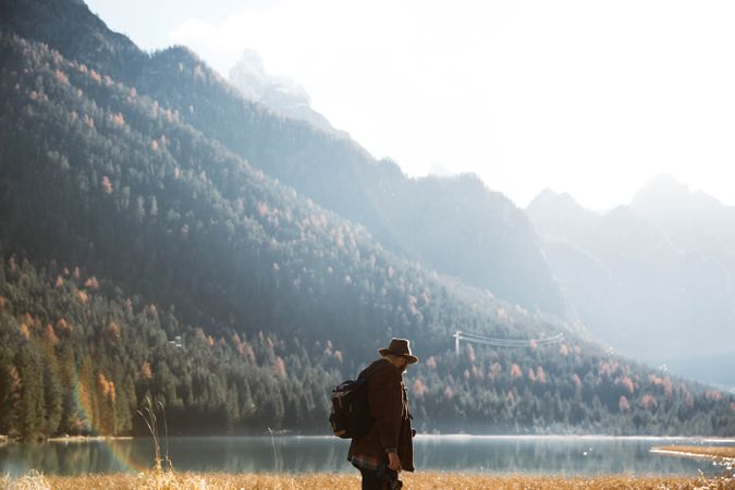 Man delighting in views near lake and mountains
