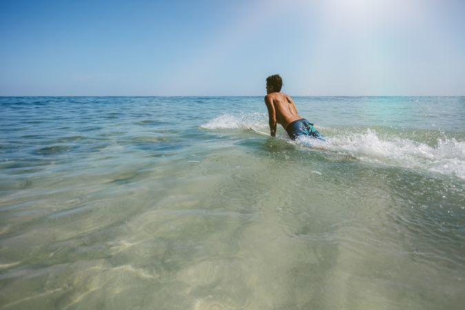 Young man enjoying a surf in sea water