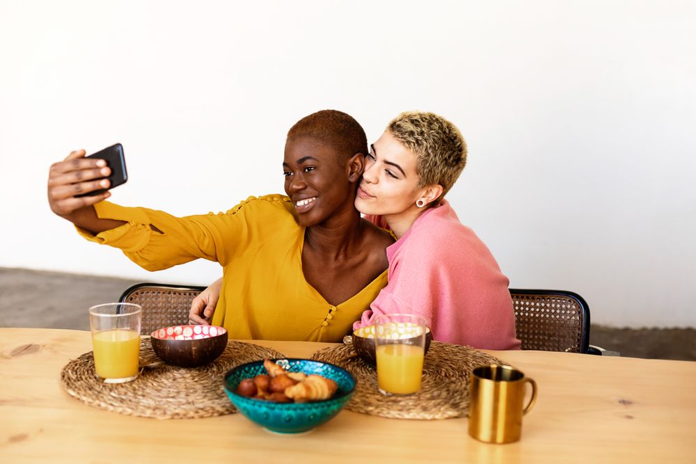 Two female friends having breakfast together at home