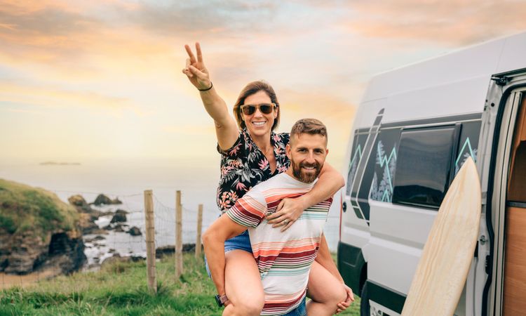 Playful couple outside motorhome with beautiful view