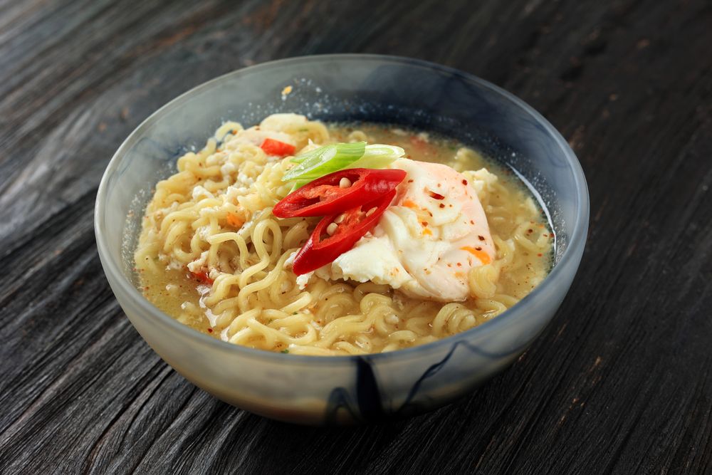 Bowl of instant ramen noodles with egg and vegetables