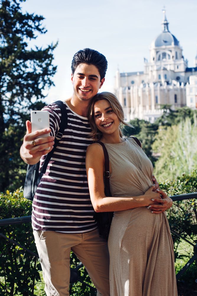 Happy young couple taking selfie in park
