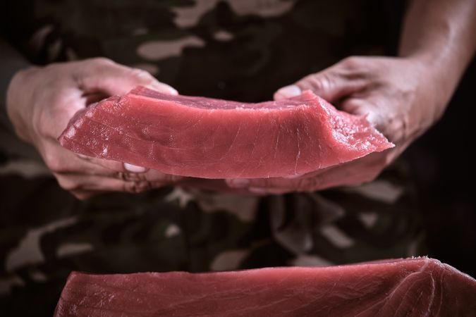 Male chef holding delicious portion of fresh bluefin tuna