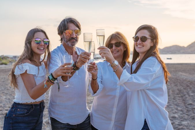 Happy family drinking wine on beach