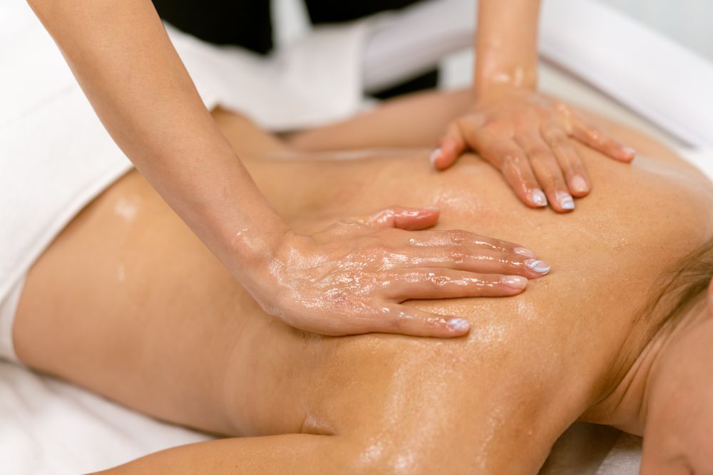 Masseuse giving an oily massage to a person