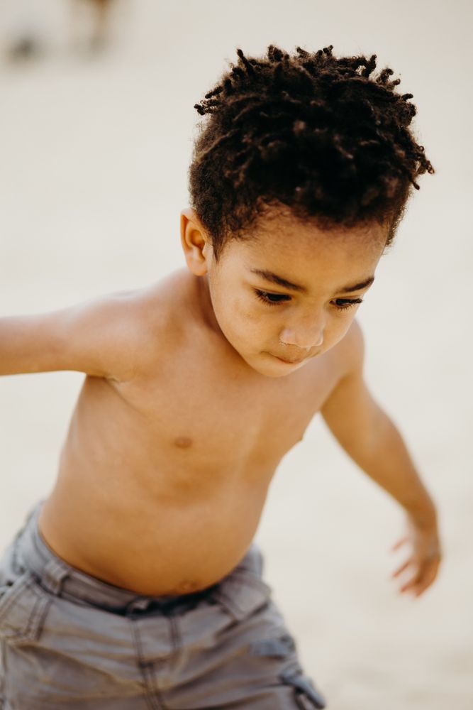 Black boy playing on beach
