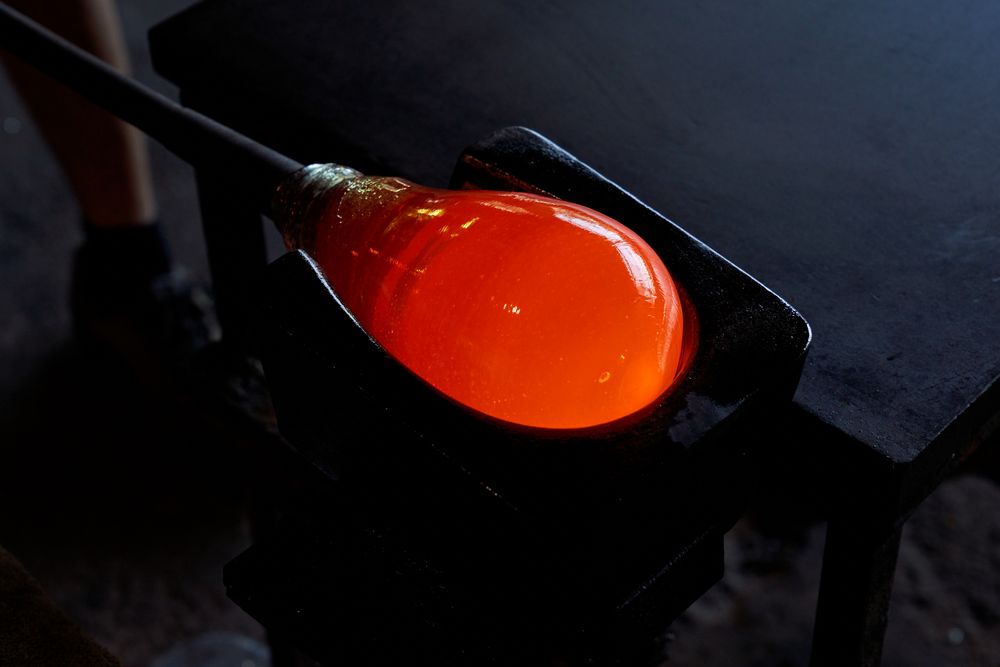 Liquid glass on blowpipe on marver
