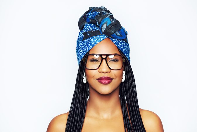 Studio portrait of woman with a satisfied expression wearing a blue wrap on her head