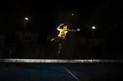 Man playing padel in darkness