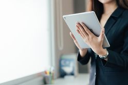 Hand of professional female hand holding a digital tablet with copy space