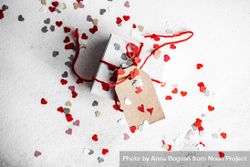 St. Valentine day concept with small gift wrapped in red ribbon and heart confetti 5pgg18