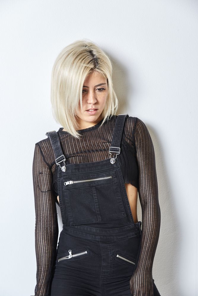 Sad blonde female in dark overalls