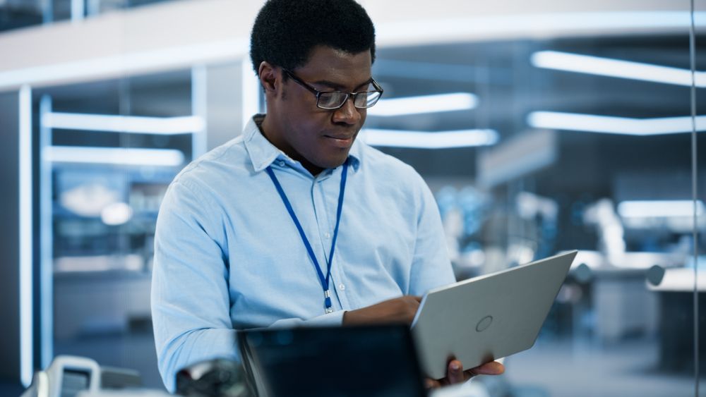 Black Man Wearing Glasses Using Laptop Computer.