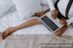 Woman using laptop on bed 5zppmb