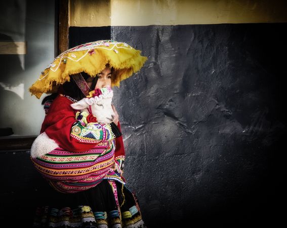 Woman in Chiapas dress holding baby goat