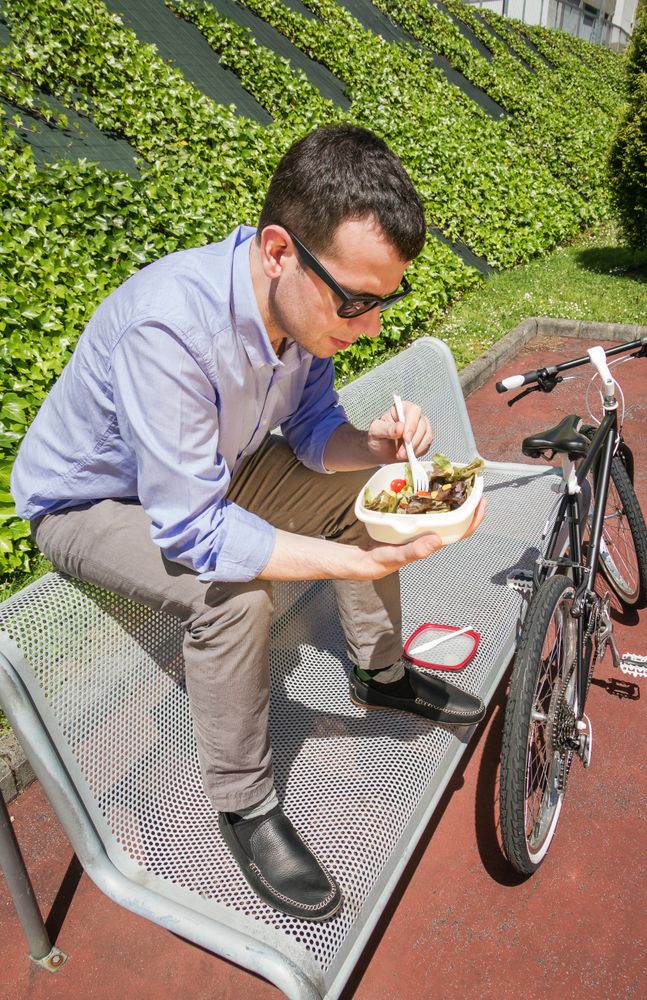 Young business man eating at lunch break outdoors