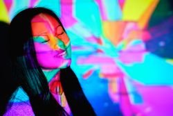 Dreamy Asian woman under colorful neon lights
