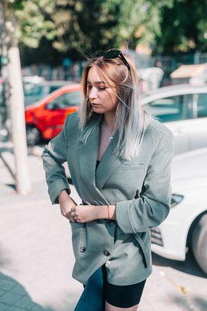 Stylish businesswoman with laptop on legs on street with cars