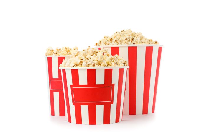 Striped buckets with popcorn isolated on plain background