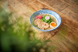 Delicious ramen soup with soft egg and pork meat in bowl