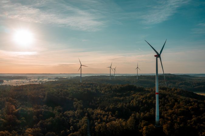 Drone image with wind turbines in the forest at sunrise in Germany