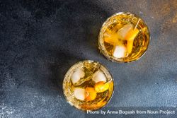 Top view of whiskey on the rocks with slices of kumquat fruit 48BG7K