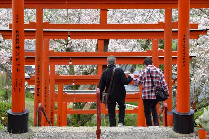 Back view of two people getting down the stairs inside of Fushimi Inari shrine in Kyoto, Japan