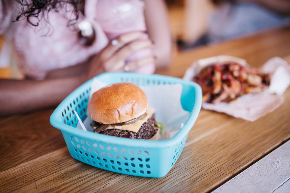 Cheeseburger in a  basket on a wooden table