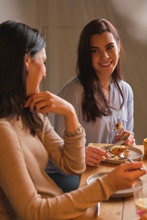 Pregnant woman and friend talking while eating dessert