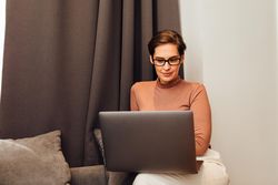 Woman in hotel room working on her laptop