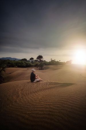 Person sitting on sand dunes of Oetune beach in East Nusa Tenggara, Indonesia