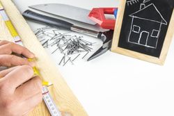 Builders hands measuring a wooden plank