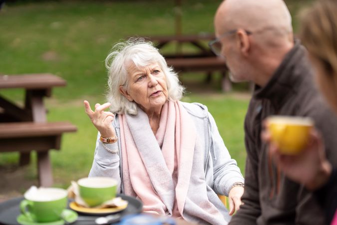 Woman having tea while having a conversation with man