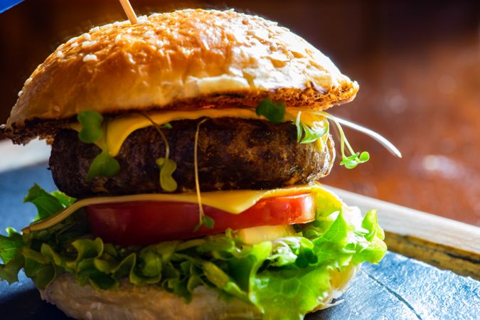 Side view of hamburger with lettuce, tomatoes & cheese