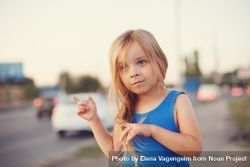 Female child standing with cars in background 5RxQRb