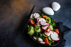 Plate of healthy vegetable salad on rustic background with copy space