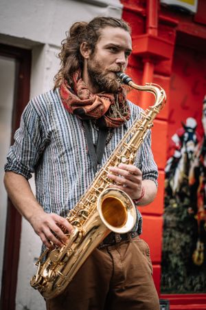 Male saxophonist plays Sax in the street