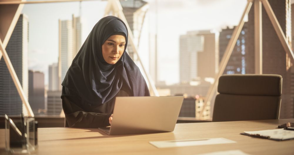 Arab Executive Manager in a Hijab Working in a Business Research and Development Office on a Laptop Computer.