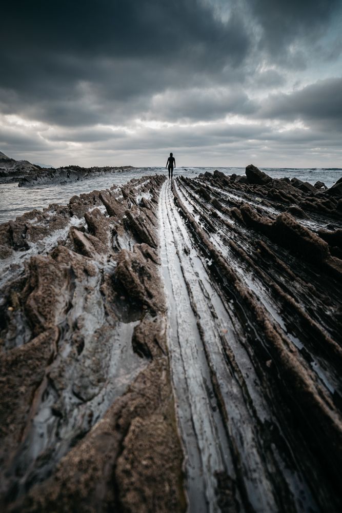 Anonymous person on rough stone shore