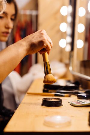 Makeup artist with powder brush and model