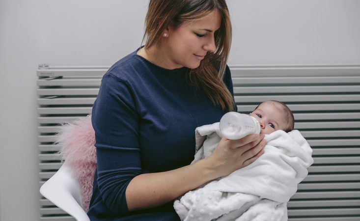 Mother giving bottle to her newborn