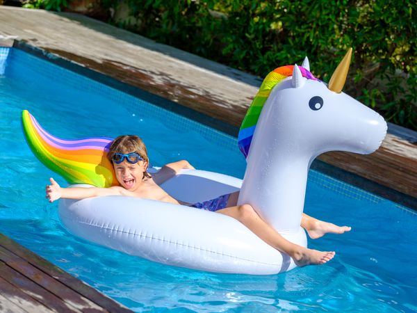 Cute kid recreating in pool lying on inflatable ring