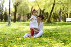 Smiling mother sitting with her daughter in park