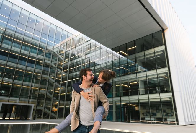 Cheerful couple having fun and hugging on street in downtown